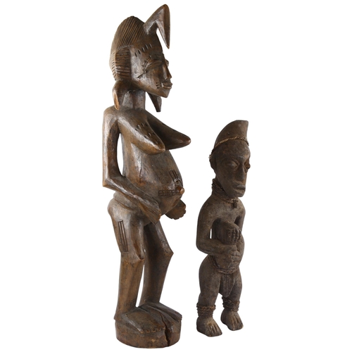 68 - Two African carved wood figures, small figure has rope and shell detail, tallest 74cm