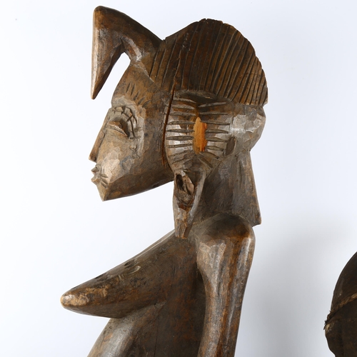 68 - Two African carved wood figures, small figure has rope and shell detail, tallest 74cm