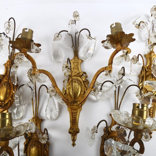 74 - A set of mid-20th century crystal hung gilded brass wall sconces, comprising 4 single light and 1 do... 