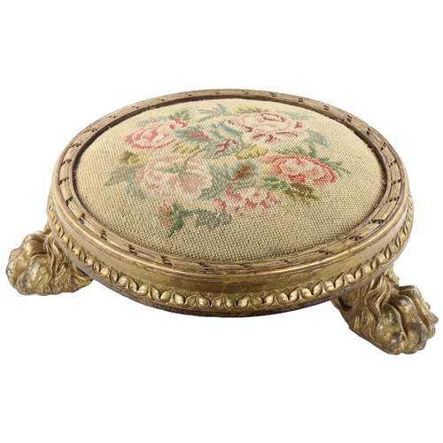 77 - A Georgian tapestry-topped footstool, with gilded wood surround and lion paw feet, diameter approx 4... 