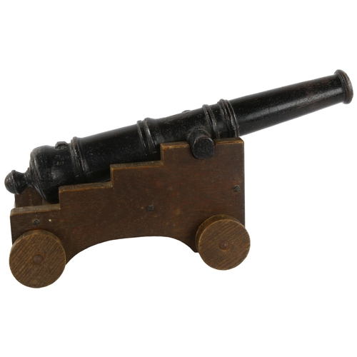 84 - A cast-iron garden cannon on oak trolley, cannon length 52cm