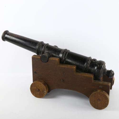 84 - A cast-iron garden cannon on oak trolley, cannon length 52cm