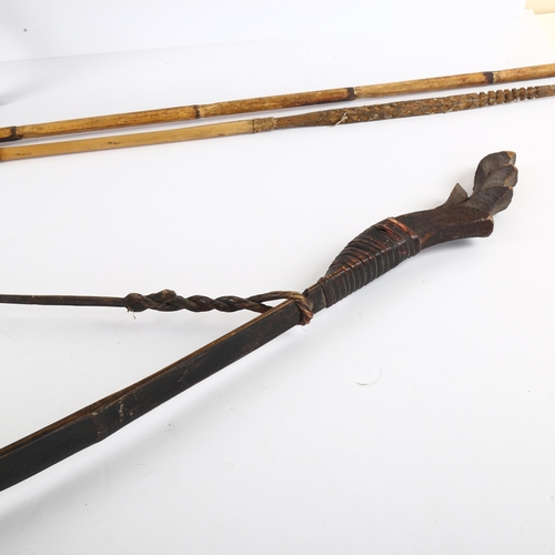 86 - A rosewood cross-bow, early 20th century, another bow, and 2 bamboo spears