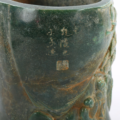 91 - A Chinese green hardstone relief carved brush pot, character marks to back and base, height 15.5cm