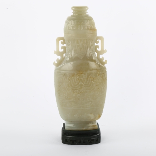 144 - A large Chinese relief carved jade 2-handled vase and cover, on dark green jade pedestal, overall he... 