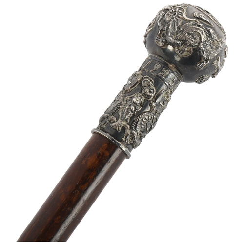 160 - A Chinese white metal-topped walking cane, with raised designs of dragon fish and crabs, initialled ... 