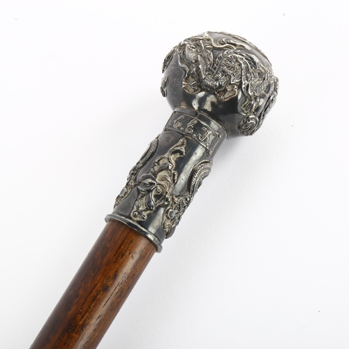 160 - A Chinese white metal-topped walking cane, with raised designs of dragon fish and crabs, initialled ... 