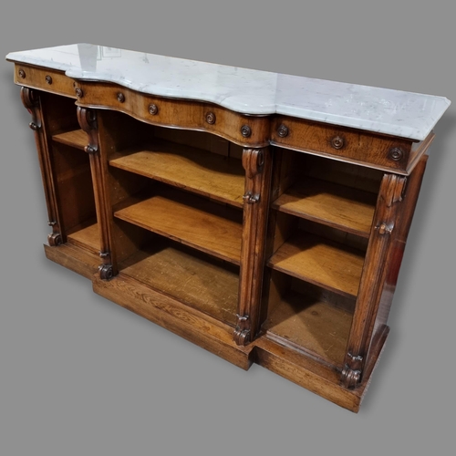 205 - A Victorian Rosewood open shelved and marble top bookcase, with serpentine breakfront and carved scr... 