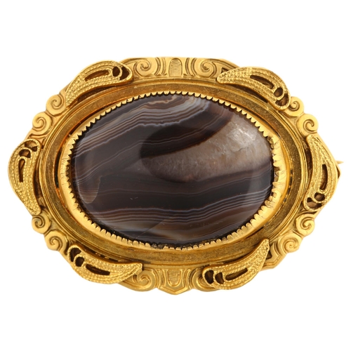 1131 - A Victorian Etruscan style banded agate brooch, unmarked yellow metal settings with wirework decorat... 