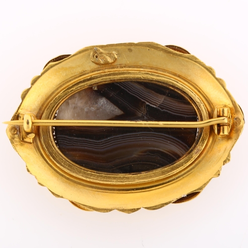 1131 - A Victorian Etruscan style banded agate brooch, unmarked yellow metal settings with wirework decorat... 