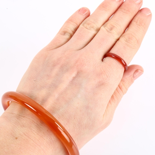 1154 - A Chinese orange jade hololith bangle and ring set, bangle internal circumference 21cm, ring size P,... 