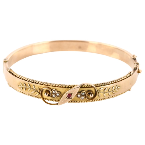 1158 - An Edwardian 9ct rose gold ruby and pearl hinged bangle, with floral motif and rope twist border, ma... 