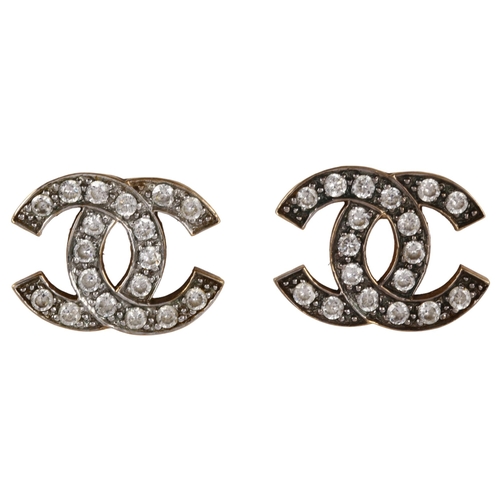 1165 - CHANEL - a pair of CC logo earrings, unmarked yellow metal settings with cubic zirconia, logo width ... 