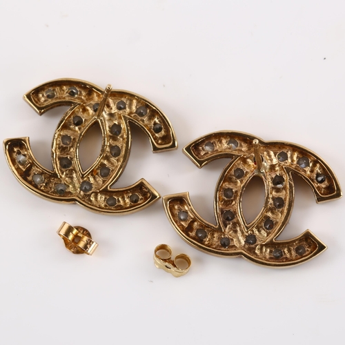 1165 - CHANEL - a pair of CC logo earrings, unmarked yellow metal settings with cubic zirconia, logo width ... 