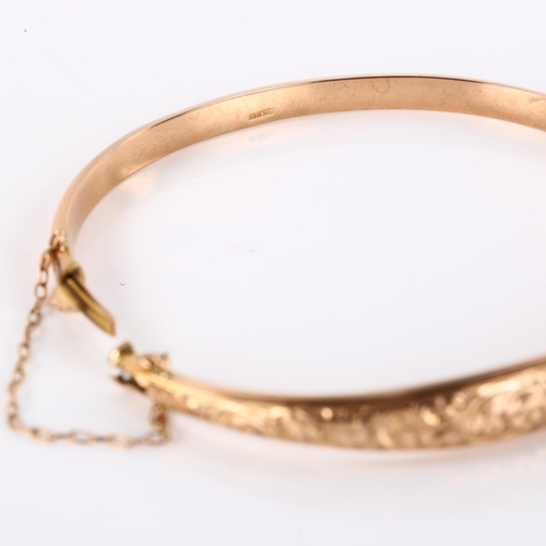 1167 - An early 20th century 9ct rose gold hinged bangle, engraved floral and foliate decoration, maker's m... 