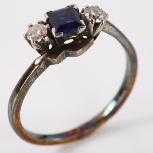 1181 - An Art Deco 18ct gold three stone sapphire and diamond crossover ring, set with square step-cut sapp... 