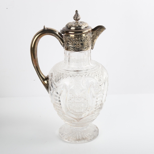 1516 - An Edwardian silver-mounted glass Claret jug, with relief embossed decoration and acanthus leaf fini... 