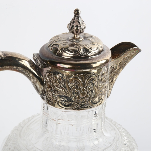 1516 - An Edwardian silver-mounted glass Claret jug, with relief embossed decoration and acanthus leaf fini... 