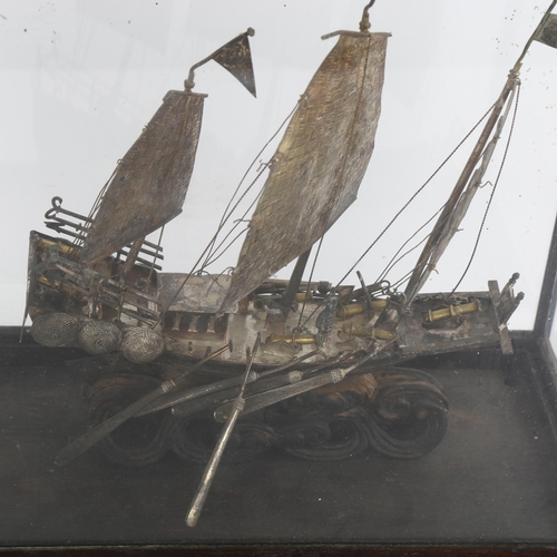 1520 - A Chinese white metal model junk boat, in glazed display case, W26cm, H27cm, D13cm