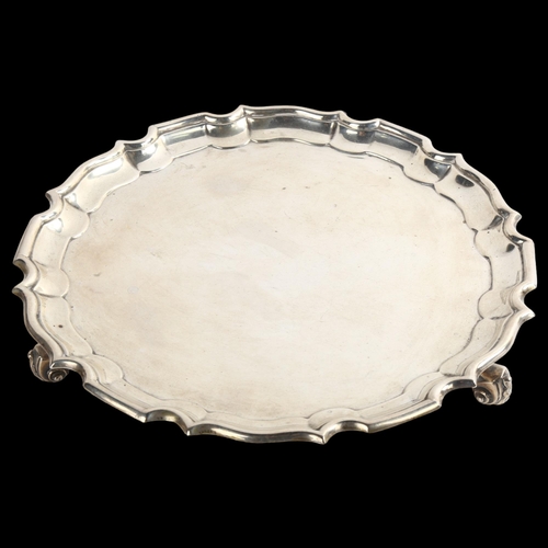 1535 - A Victorian circular silver salver, with scalloped rim and scrolled acanthus leaf feet, possibly by ... 