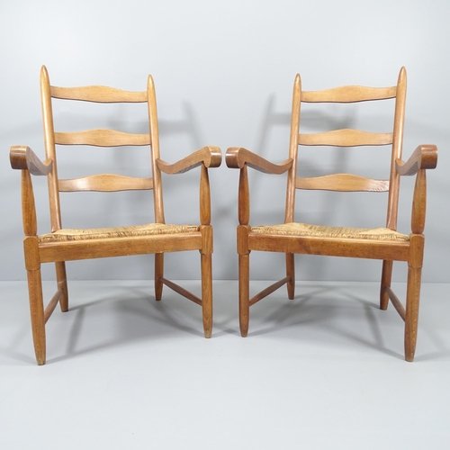 2024 - A pair of mid-century ladderback lounge chairs, in oak with rush seats.