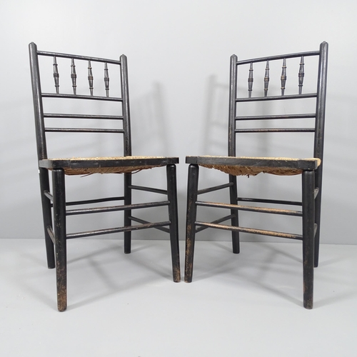 2040 - A pair of Morris & Company Arts & Crafts spindle back ebonised Sussex chairs with rush seats.