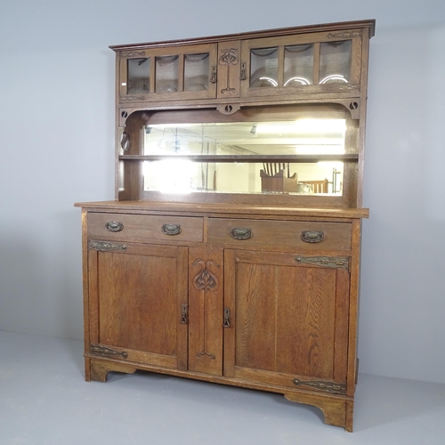 2502 - An antique oak Arts & Crafts two section dresser, with mirrored plate rack and carved and pierced de... 