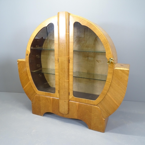 2508 - An Art Deco walnut display cabinet of circular form, with two glazed doors and two fixed glass shelv... 