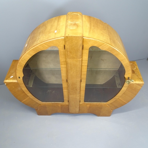 2508 - An Art Deco walnut display cabinet of circular form, with two glazed doors and two fixed glass shelv... 