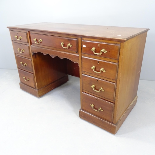 2570 - An antique mahogany kneehole writing desk, with nine drawers and raised on casters. 138x83x57cm. Kne... 