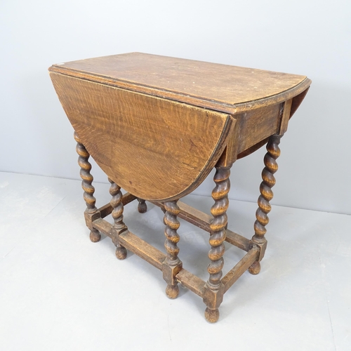 2573 - An antique oak oval gateleg table, with barley twist legs. 77x72x37cm.