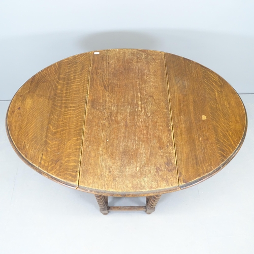 2573 - An antique oak oval gateleg table, with barley twist legs. 77x72x37cm.