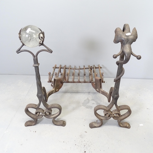 2638 - A pair of wrought Iron fire dogs, one topped with a crystal ball and the other with an elephant head... 