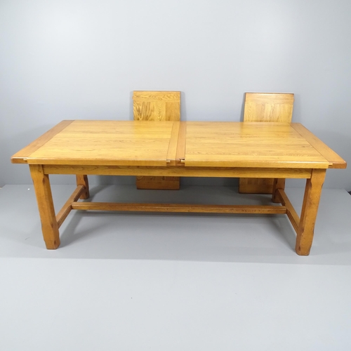 2053 - A modern light oak draw-leaf dining table. 220 (extending to 310)x78x102cm.