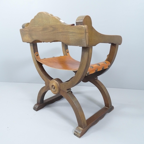 2091 - A modern carved oak Savonarola chair, with leather seat.