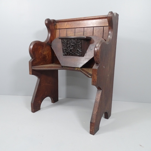 2141 - An antique oak church misericord, the seat rising to reveal a carved panel and rest. Dimensions over... 