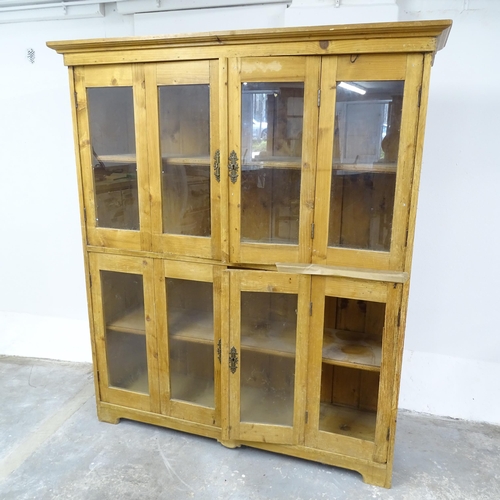 2653 - An antique pine bookcase, with four glazed panelled bi-fold doors and four fixed shelves. 140x160x43... 