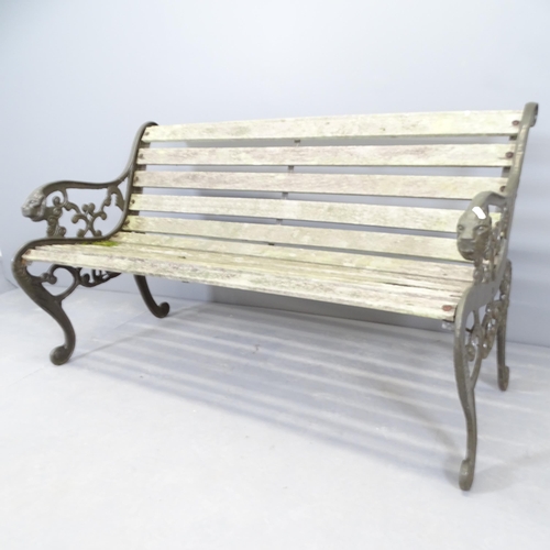 2667 - A teak slatted garden bench with cast iron ends, with lion decoration. 130x73x65cm.