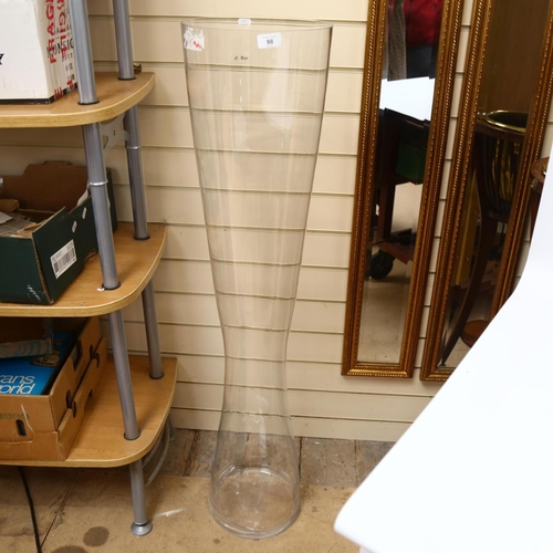 98 - A large floor standing clear glass vase of waisted form, H120cm