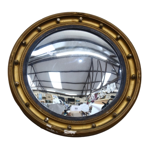 99 - A gilt-framed circular convex wall mirror, diameter 54cm (frame damaged)