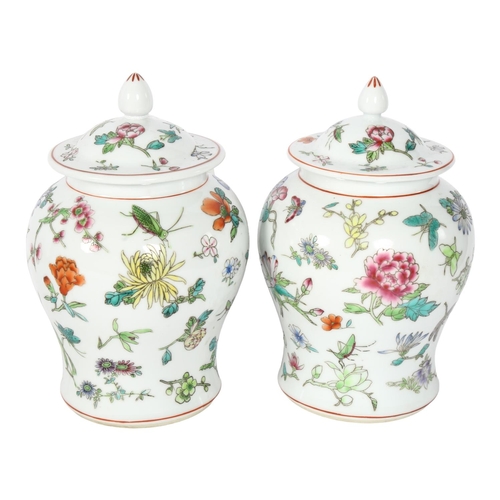 331 - A pair of Chinese porcelain jars and covers, with painted floral and insect decoration, 22cm