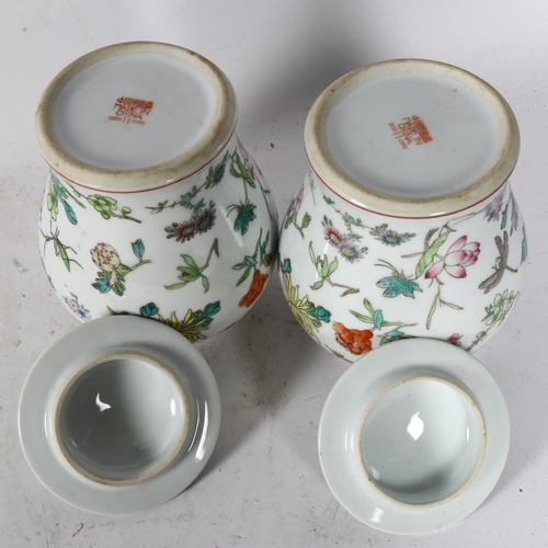 331 - A pair of Chinese porcelain jars and covers, with painted floral and insect decoration, 22cm