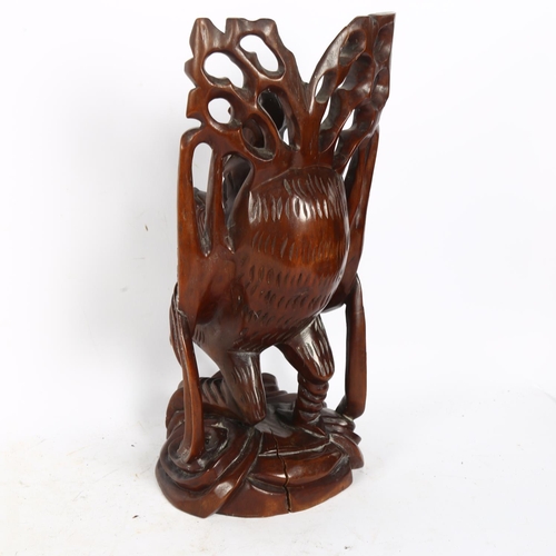 346 - A Chinese carved and stained wood figure riding a bird, height 38cm