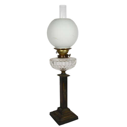 534 - An Antique engraved brass oil lamp with glass font, chimney and globular shade, H70cm