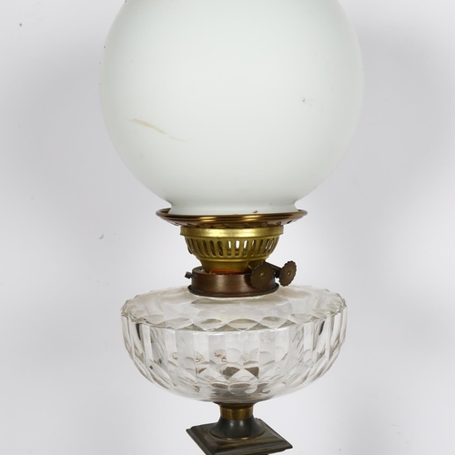 534 - An Antique engraved brass oil lamp with glass font, chimney and globular shade, H70cm