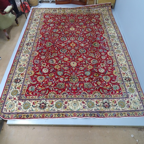 2281 - A red and cream-ground Tabriz carpet, with floral design. 338x298cm