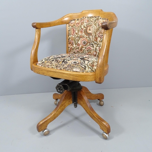 2163 - An early 20th century oak and upholstered swivel desk chair.