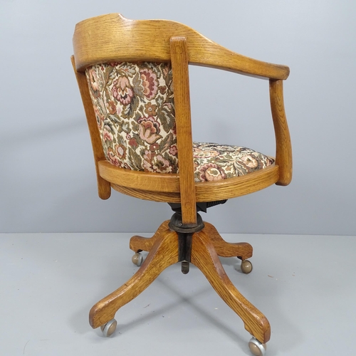 2163 - An early 20th century oak and upholstered swivel desk chair.