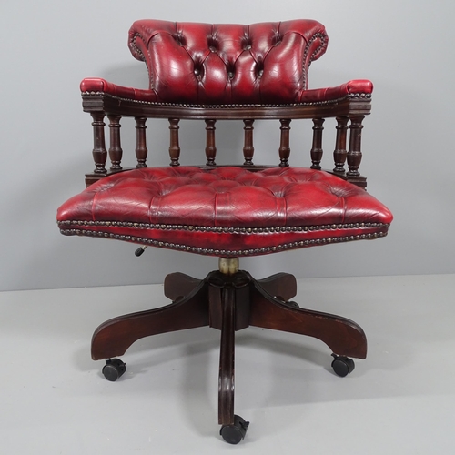 2172 - A reproduction mahogany and button-back leather upholstered swivel bow arm desk chair.