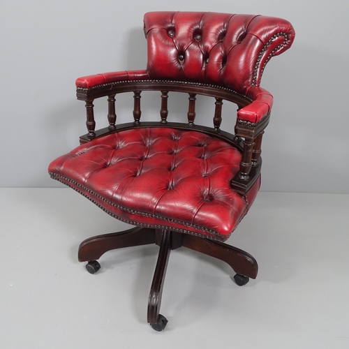 2172 - A reproduction mahogany and button-back leather upholstered swivel bow arm desk chair.